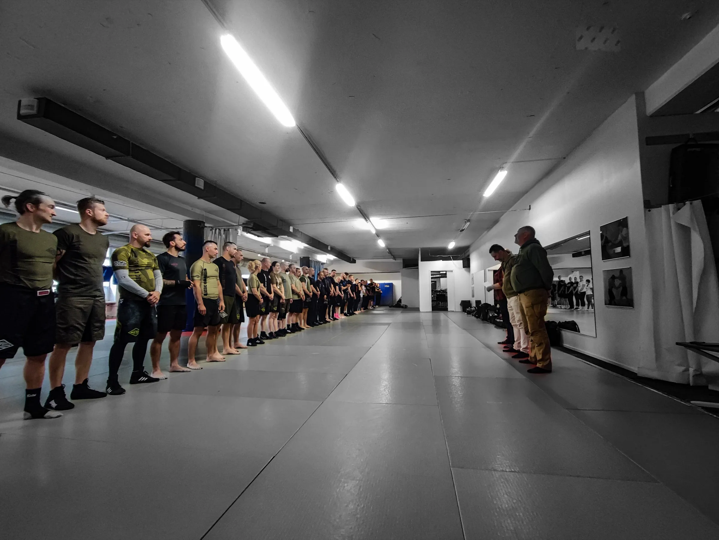A full class lined up across the training hall, facing their instructors